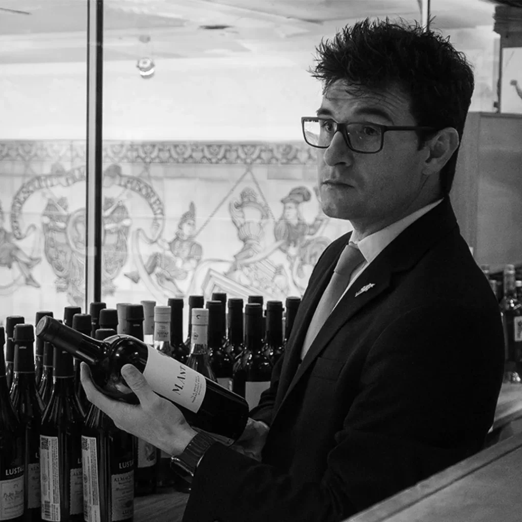 Meet our team: Alvaro Correas holding a bottle of wine