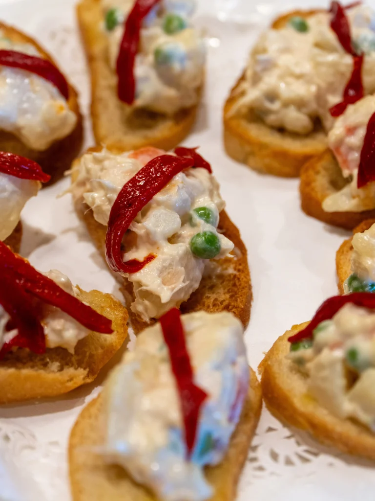 Catering: canapes topped with creamy salad and red pepper