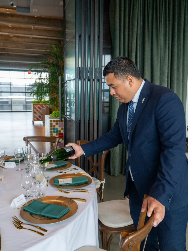 Catering: server setting a table at a rooftop wedding