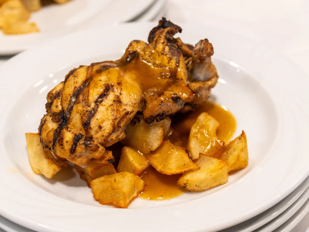Catering: roasted chicken with potatoes on a white plate