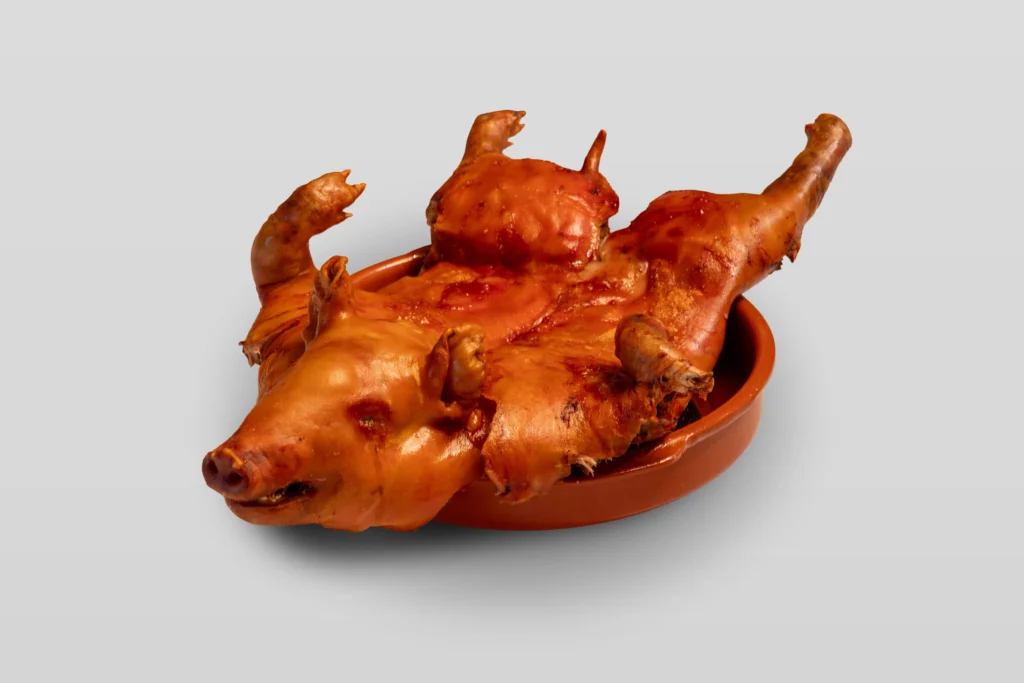 Catering: roast suckling pig (cochinillo) served in a clay dish