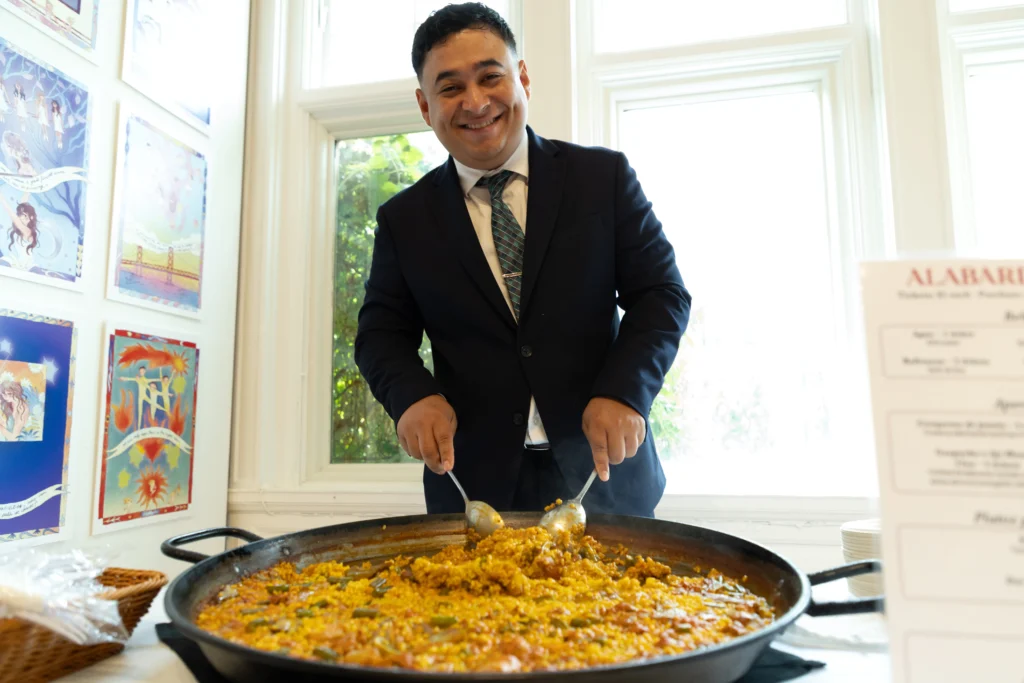 Catering: chef stirring a large pan of paella at a catered event